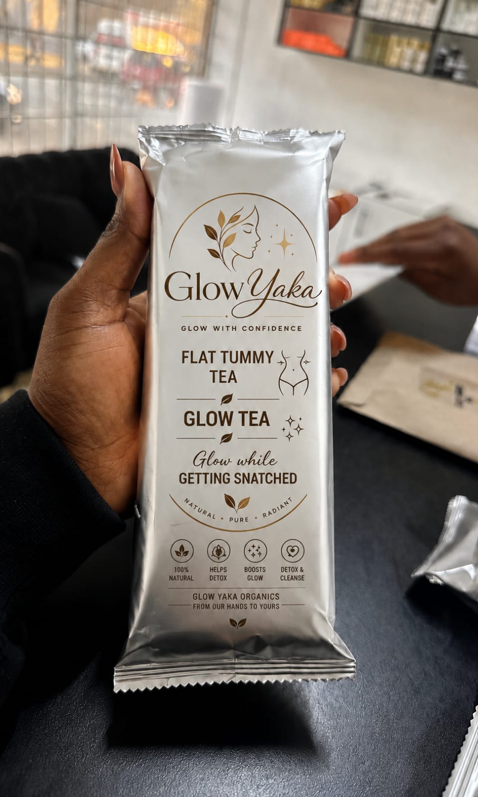 Glow Yaka Flat Tummy Tea sachet held in hand